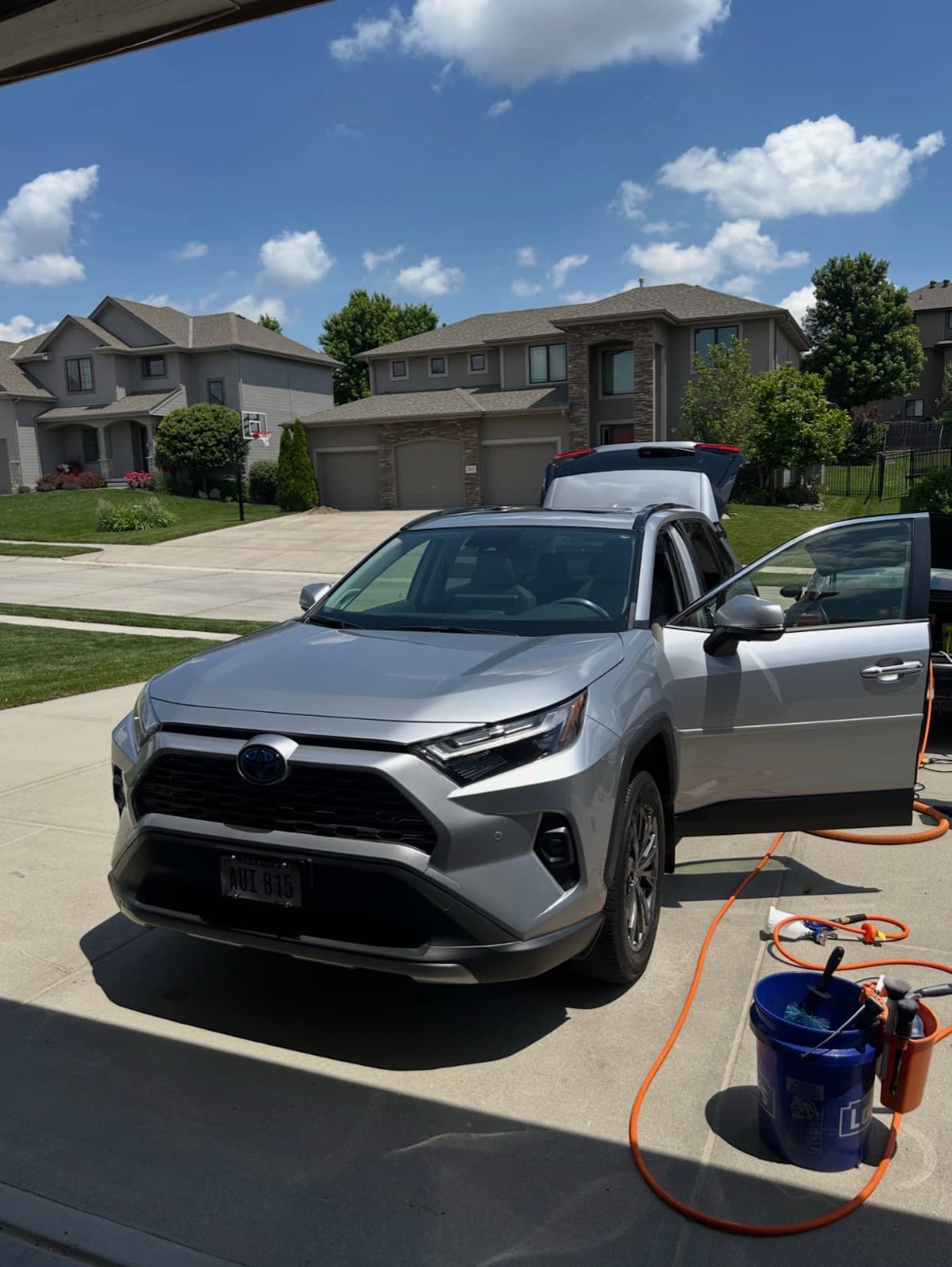 Mobile detail in progress on a Toyota RAV4 in an Overland Park driveway — buckets, hose, and gear on site